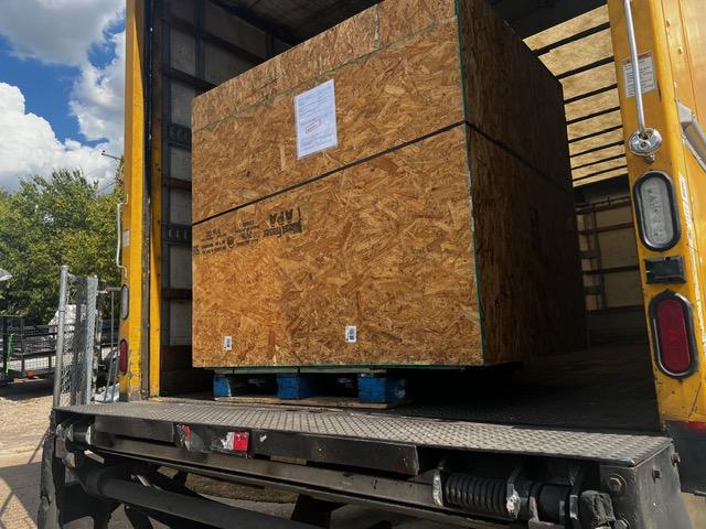 Large wooden shipping crate on pallet being loaded, custom crating and packaging services in Fort Worth