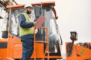 indian-man-working-male-yellow-vest-man-near-tractor 1 (1) (1) Large wooden shipping crate on pallet being loaded, custom crating and packaging services in Fort Worth
