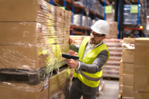 indian-man-working-male-yellow-vest-man-near-tractor 1 Large wooden shipping crate on pallet being loaded, custom crating and packaging services in Fort Worth